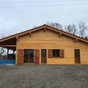 Maison ossature bois bardage Mélèze, couverture tuiles, menuiseries PVC ton bois à Dorat