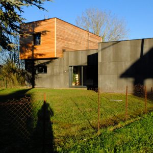 Maison ossature bois bardage panneaux ciment et bardage Mélèze, couverture membrane d&rsquo;étanchéité, menuiseries aluminium à Creuzier le Neuf