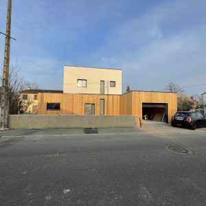 Maison ossature bois, bardage Mélèze claire voie et enduit, couverture membrane d&rsquo;étanchéité, menuiseries aluminium à Creuzier le Vieux